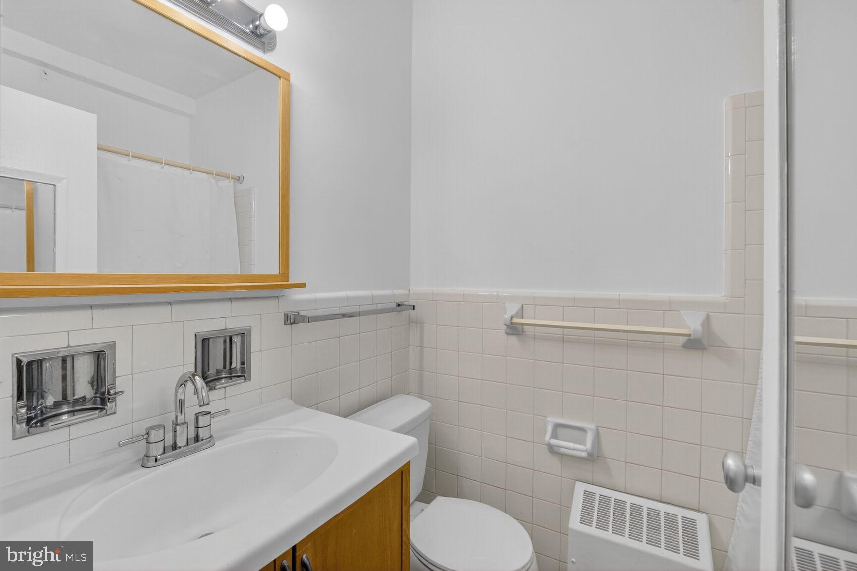 1711 Massachusetts Avenue Northwest, Unit 825 Washington, DC 20036 - Photo 11 of 16 a bathroom with a sink toilet and mirror