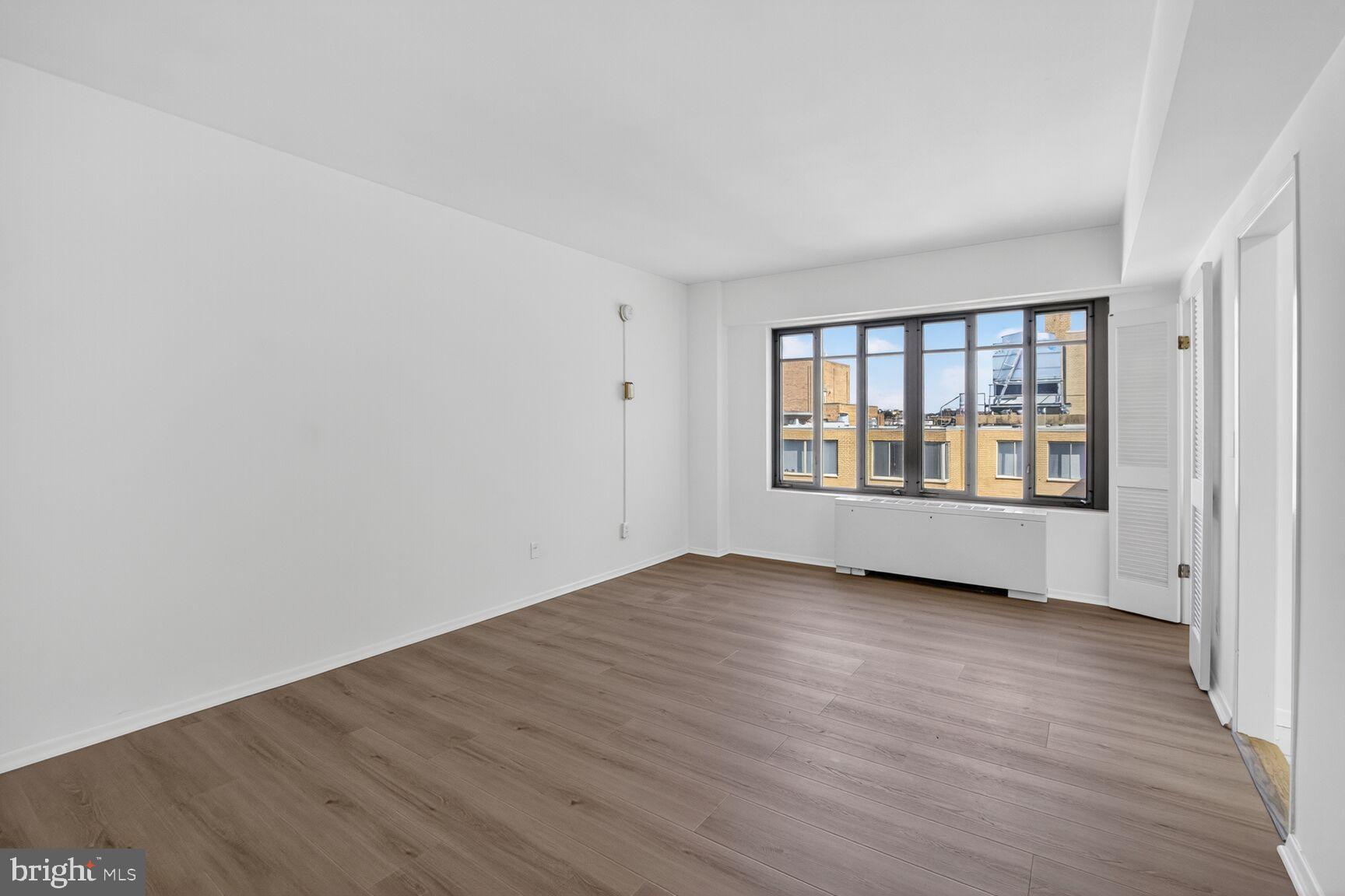 1711 Massachusetts Avenue Northwest, Unit 825 Washington, DC 20036 - Photo 3 of 16 an empty room with wooden floor and windows
