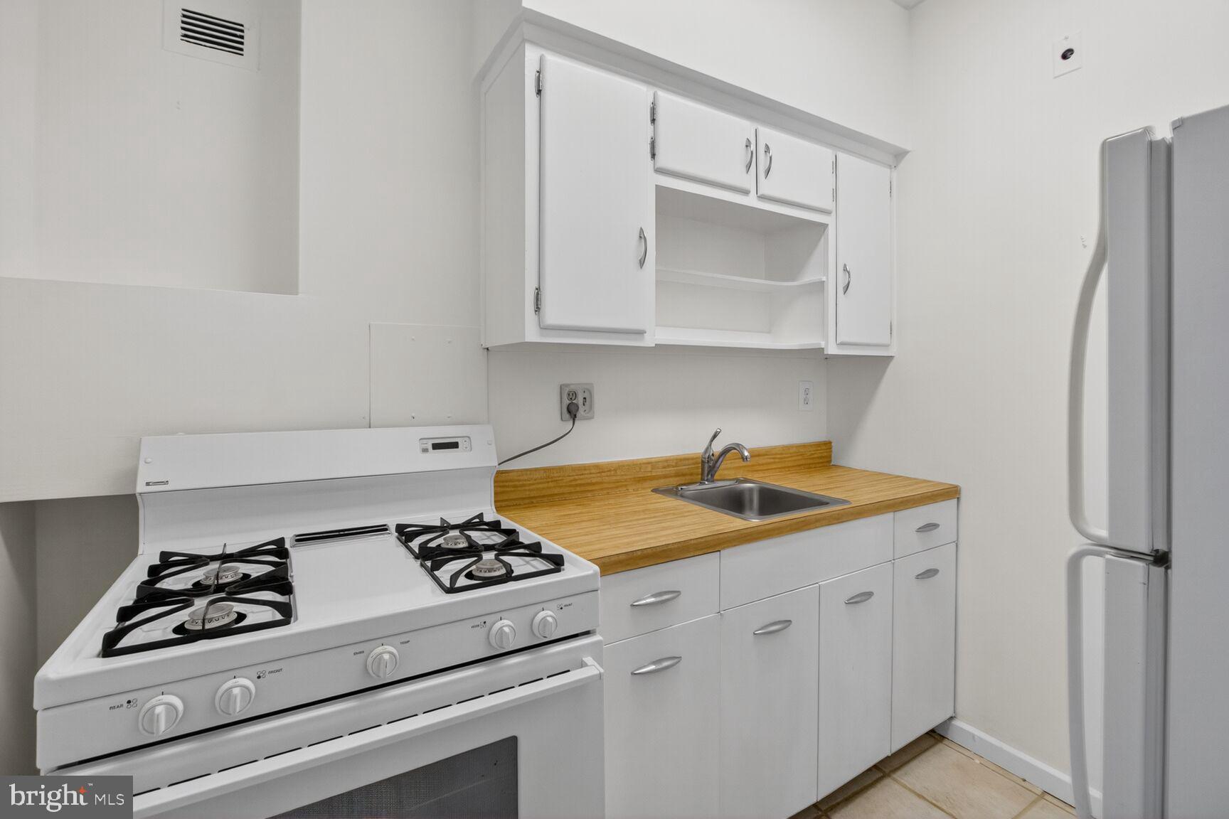 1711 Massachusetts Avenue Northwest, Unit 825 Washington, DC 20036 - Photo 6 of 16 a kitchen with white cabinets and white appliances
