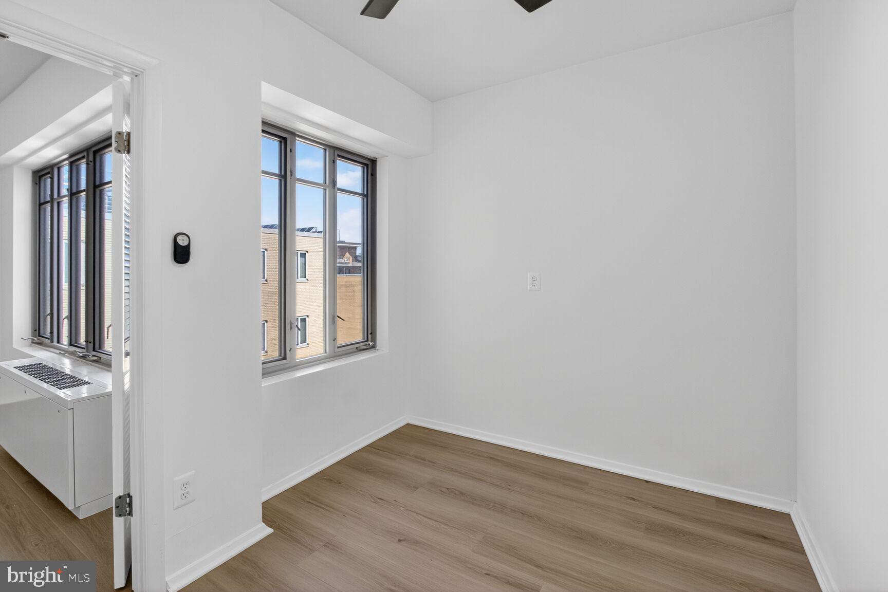 1711 Massachusetts Avenue Northwest, Unit 825 Washington, DC 20036 - Photo 7 of 16 a view of an empty room with wooden floor and a window