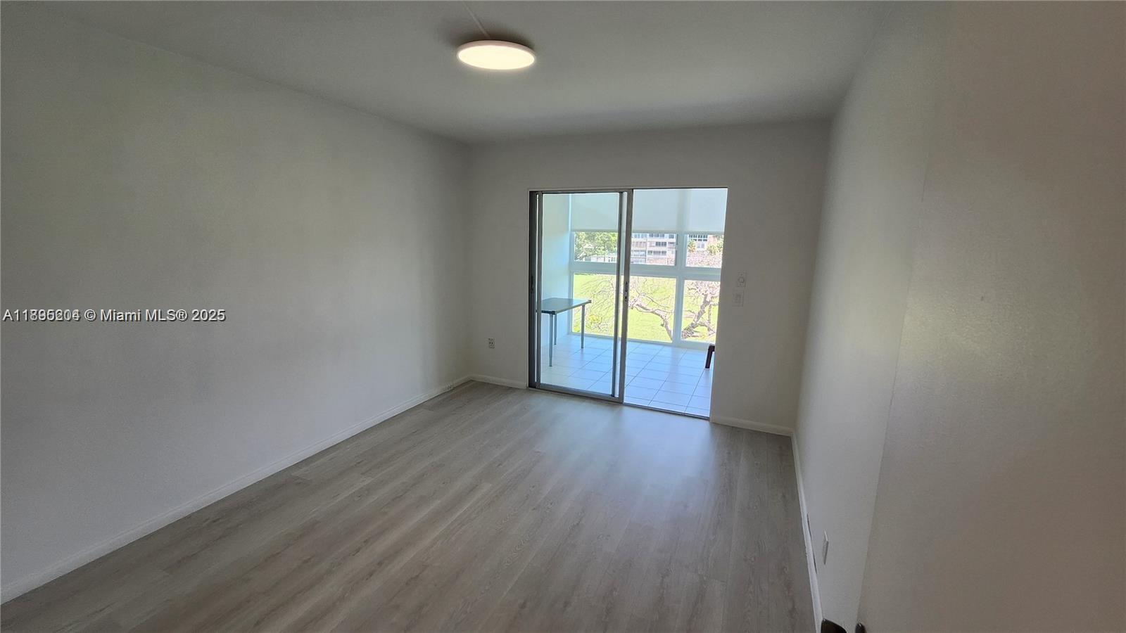 4065 Lyndhurst North, Unit 4065 Deerfield Beach, FL 33442 - Photo 13 of 34 an empty room with wooden floor and windows