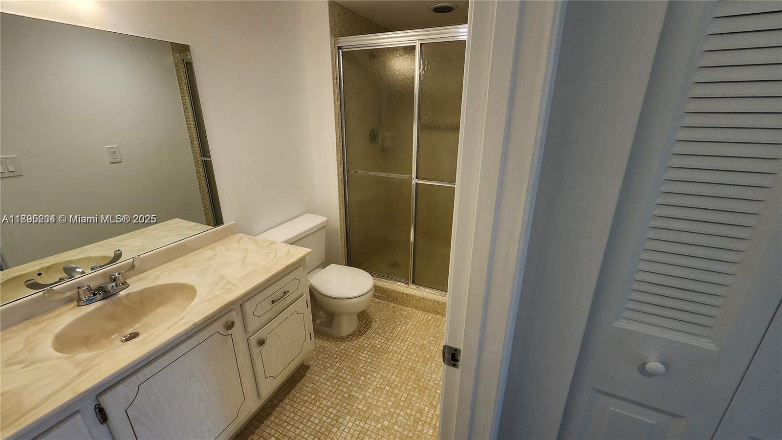 4065 Lyndhurst North, Unit 4065 Deerfield Beach, FL 33442 - Photo 15 of 34 a bathroom with a granite countertop sink toilet and shower