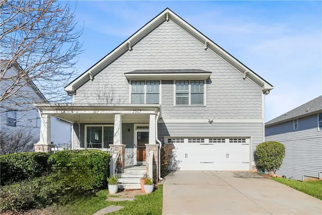 a view of a white house next to a yard