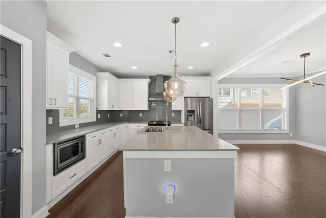 a kitchen with kitchen island a stove a sink a refrigerator a center island and a wooden floor