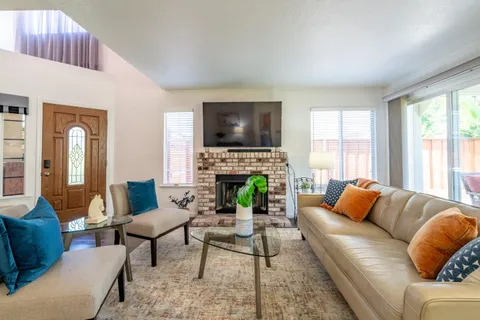 a living room with furniture a fireplace and a flat screen tv