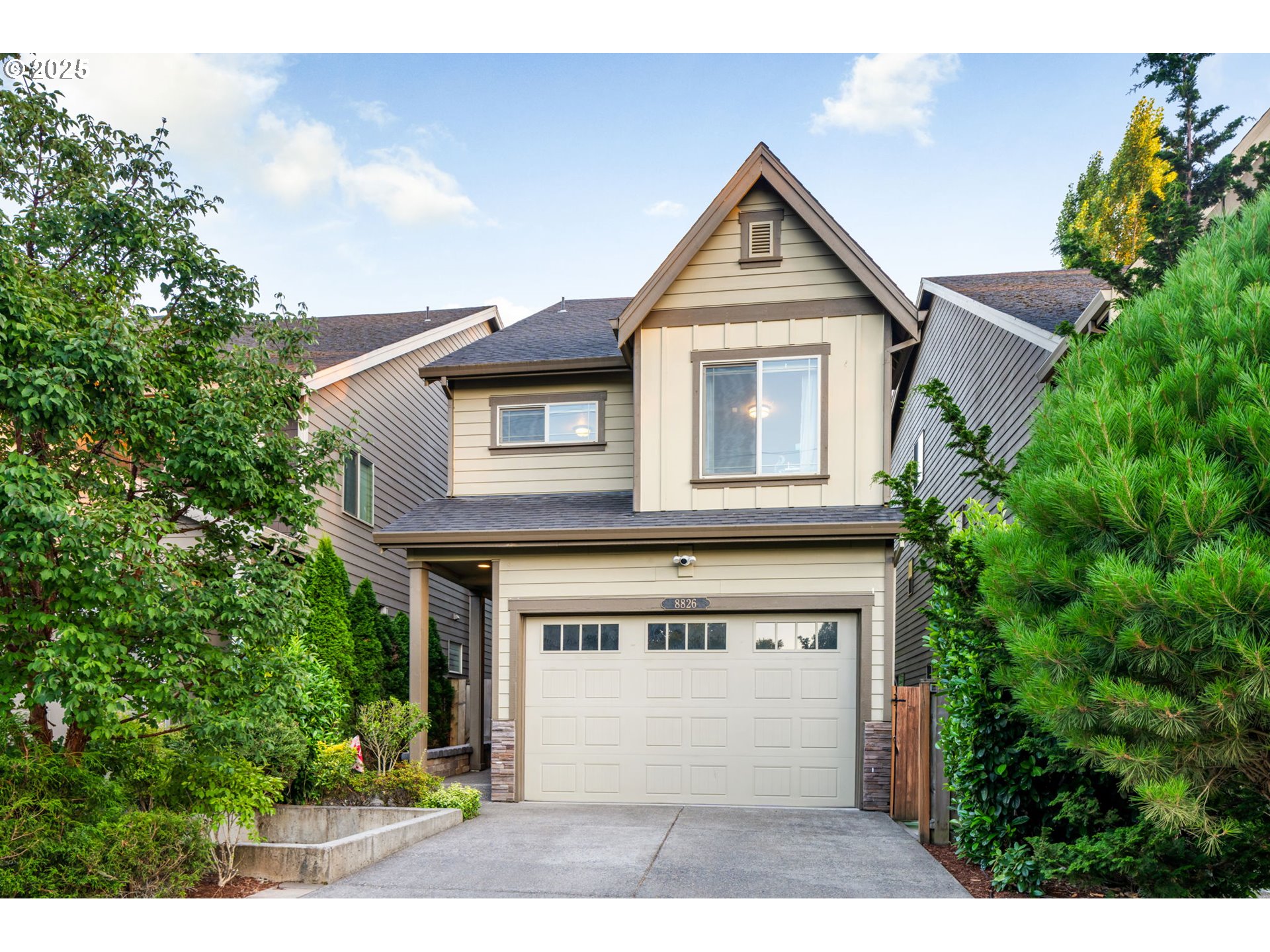 8826 Southwest Spruce Street Portland, OR 97223 - Photo 2 of 34 a front view of a house with a yard and garage