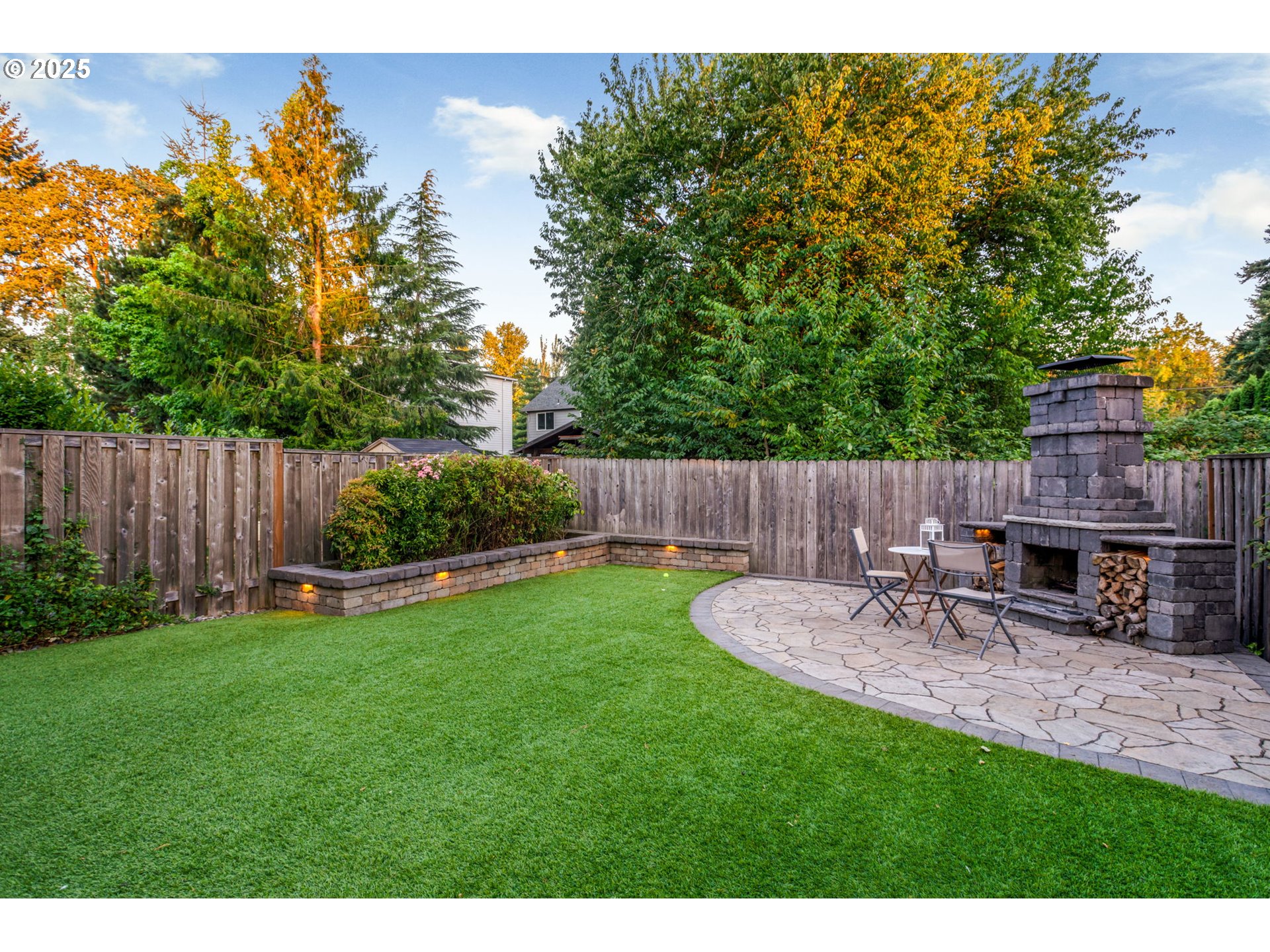 8826 Southwest Spruce Street Portland, OR 97223 - Photo 30 of 34 a view of a backyard with table and chairs and wooden fence