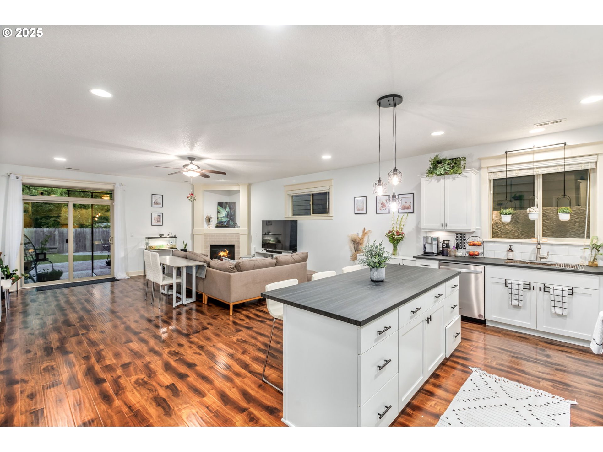 8826 Southwest Spruce Street Portland, OR 97223 - Photo 7 of 34 a open kitchen with kitchen island granite countertop a sink cabinets and wooden floor