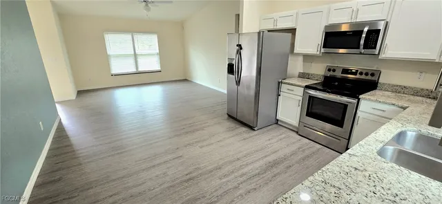 a kitchen with stainless steel appliances wooden floors and wooden cabinets