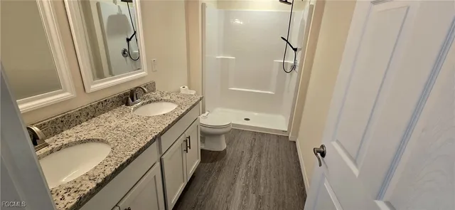 a bathroom with a granite countertop sink toilet and shower
