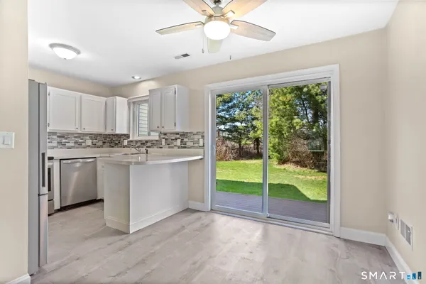 a kitchen with white cabinets and white appliances