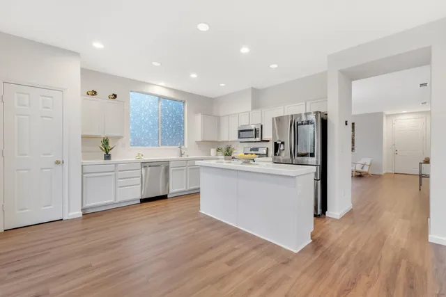 a kitchen with white cabinets and stainless steel appliances