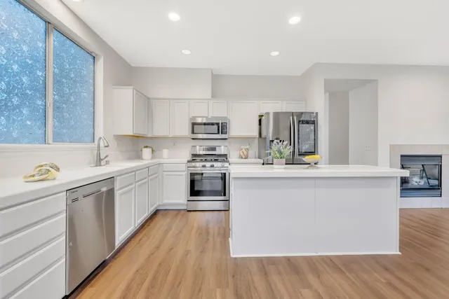 a kitchen with a sink a counter top space stainless steel appliances and cabinets