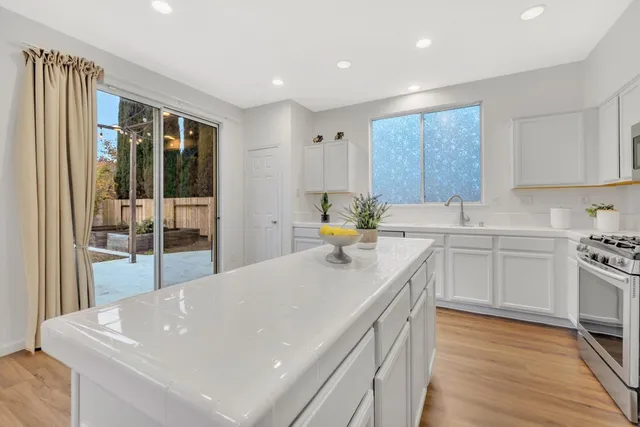 a kitchen with stainless steel appliances a sink a stove top oven a counter space and cabinets