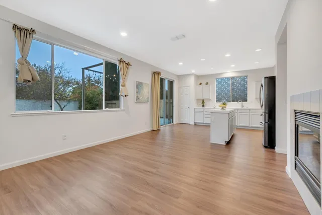 a view of empty room with wooden floor and a window