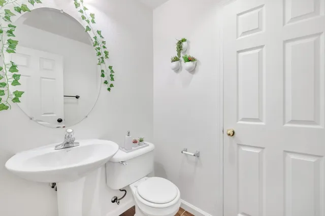 a bathroom with a sink toilet and a mirror
