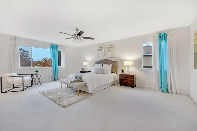 a spacious bedroom with a bed and a chandelier