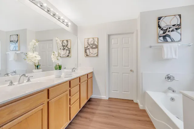 a spacious bathroom with a tub sink and mirror