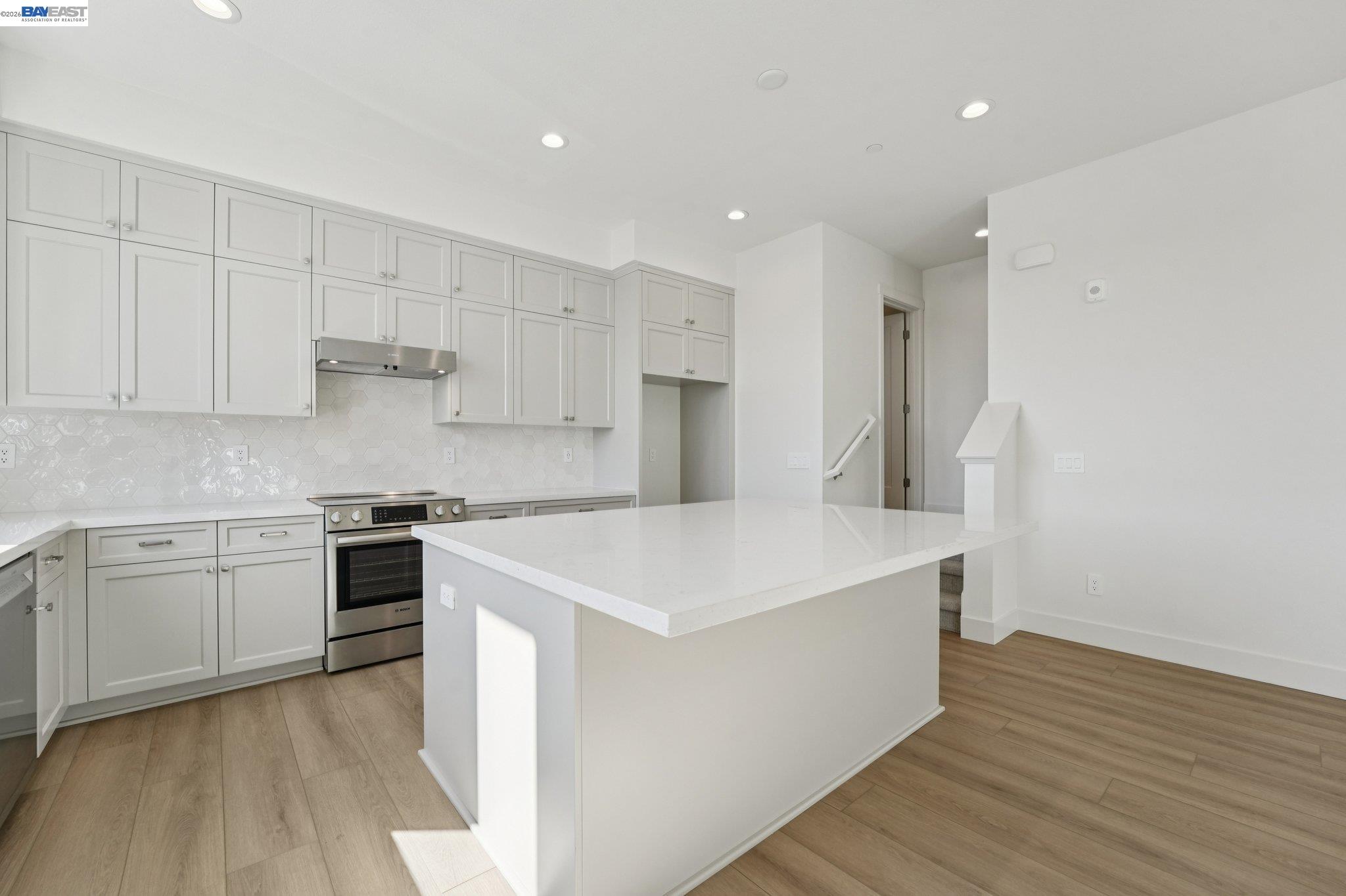 1933 Grand Street Alameda, CA 94501 - Photo 18 of 50 a kitchen with stainless steel appliances white cabinets and wooden floor