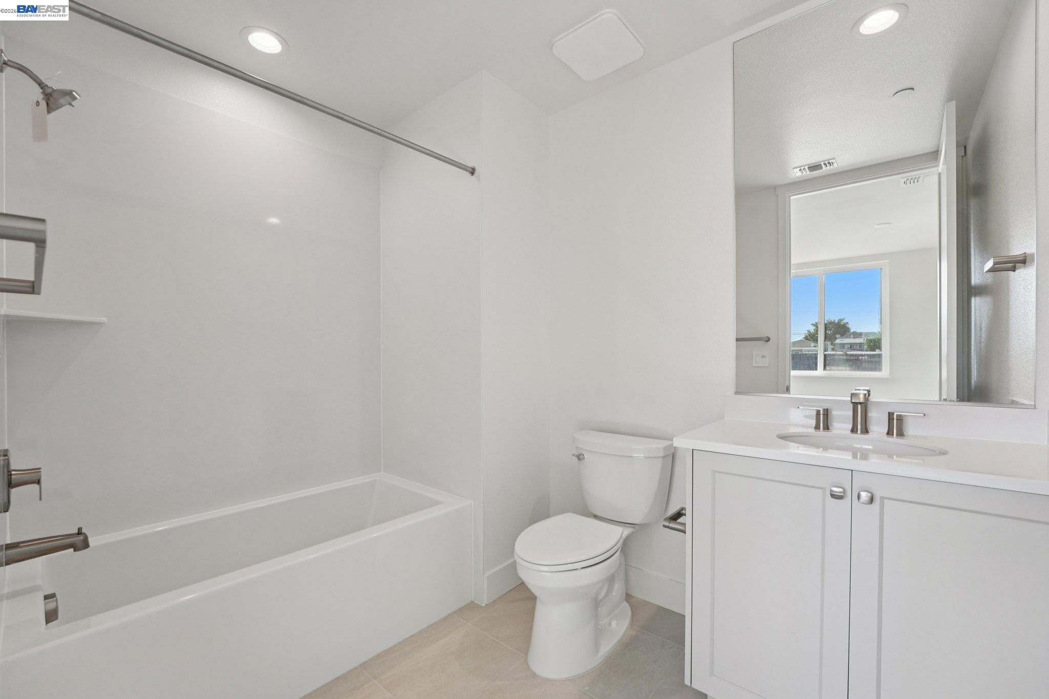 1933 Grand Street Alameda, CA 94501 - Photo 29 of 50 a bathroom with a toilet a sink a mirror a bathtub and vanity