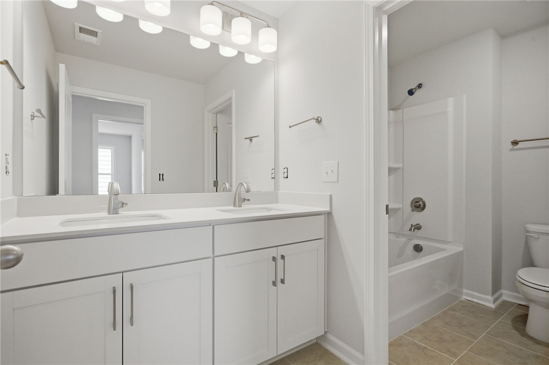 557 Hydrangea Street, Unit LOT 46 Seneca, SC 29678 - Photo 31 of 37 A well-appointed bathroom features a double vanity and a pristine shower-over-tub combination.
