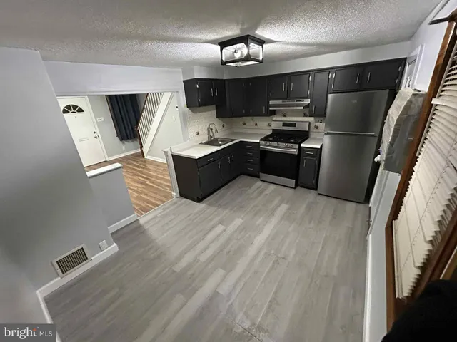 a kitchen with stainless steel appliances a refrigerator a sink a stove a microwave and cabinets