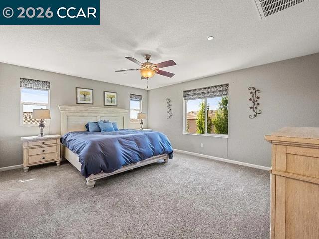 5525 Mossy Stone Way Rancho Cordova, CA 95742 - Photo 15 of 31 a spacious bedroom with a large bed and a chandelier