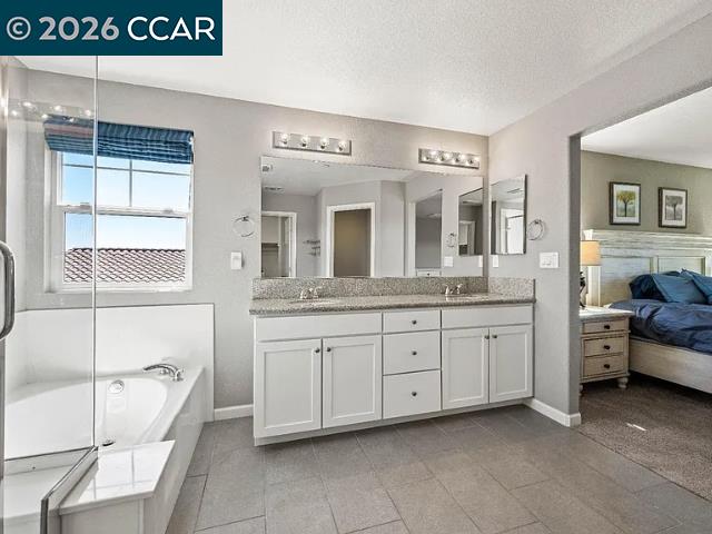 5525 Mossy Stone Way Rancho Cordova, CA 95742 - Photo 17 of 31 a spacious bathroom with a granite countertop sink and a mirror