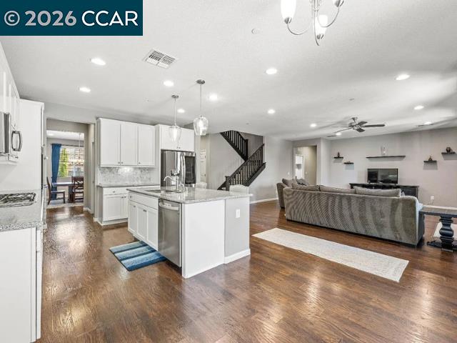 5525 Mossy Stone Way Rancho Cordova, CA 95742 - Photo 6 of 31 a large kitchen with stainless steel appliances kitchen island a large counter top and a view of living room