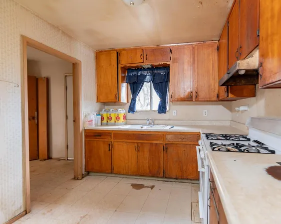 a kitchen with granite countertop a sink stove and cabinets