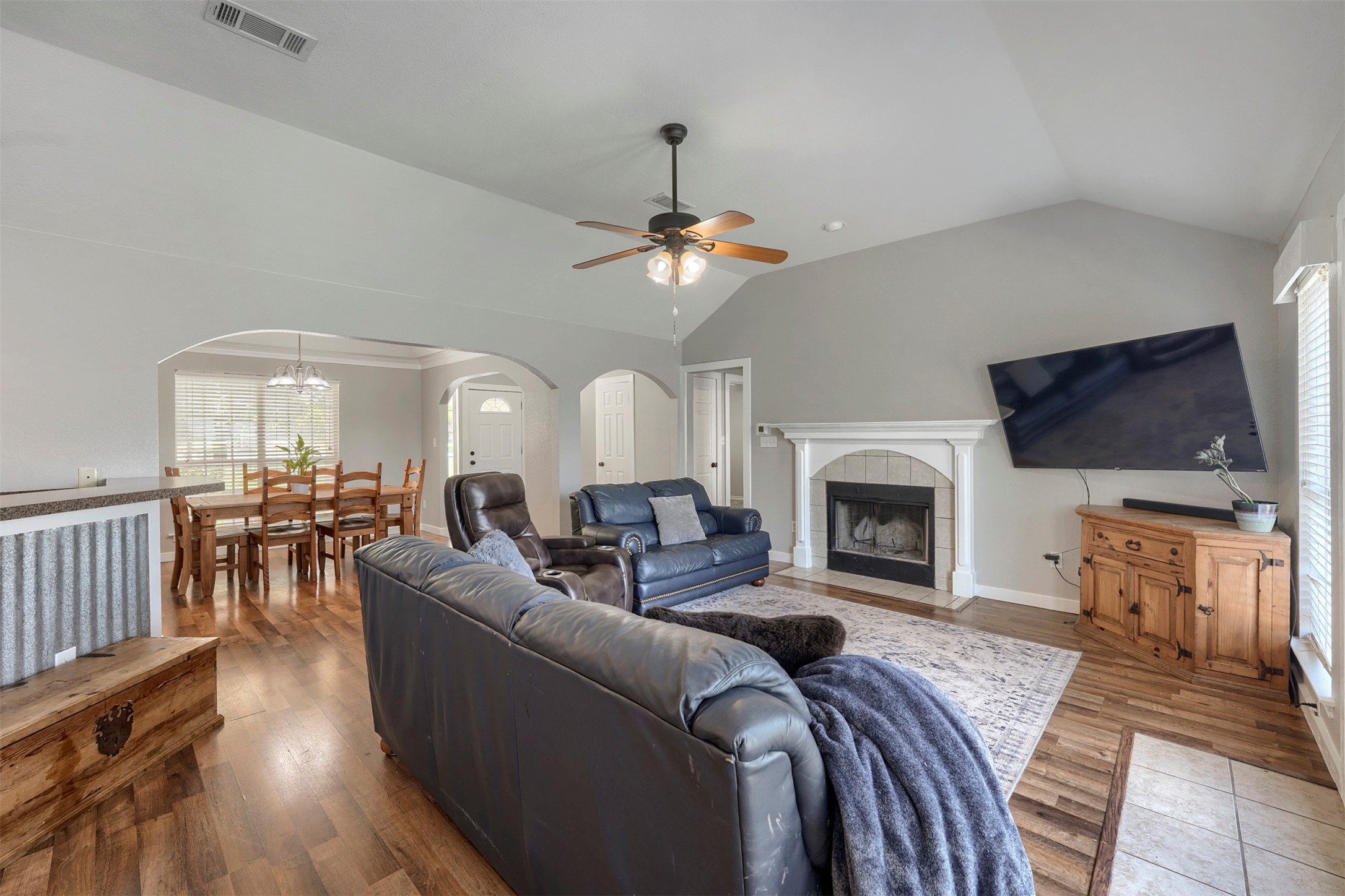 1105 2nd Street Jarrell, TX 76537 - Photo 4 of 27 Gather around a warm fireplace beneath vaulted ceilings, perfect for cozy evenings at home.