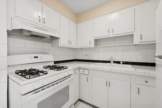 a kitchen with white cabinets and appliances