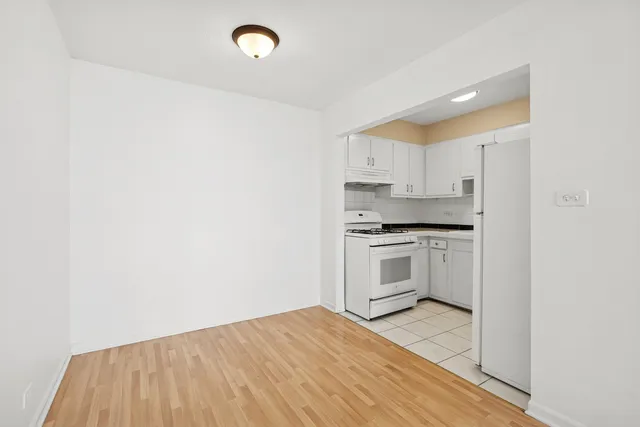 a kitchen with granite countertop white cabinets and white appliances