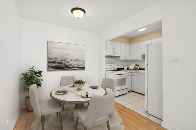 a kitchen with white cabinets and refrigerator