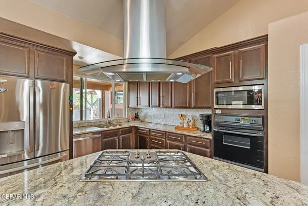 a kitchen with stainless steel appliances granite countertop a sink stove and refrigerator