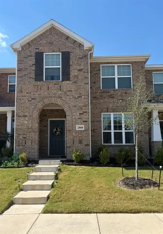 a brick house with a yard in front of it