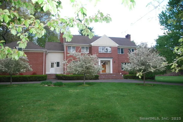 a front view of a house with a garden and plants