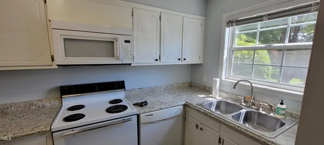 a kitchen with a sink cabinets and a window