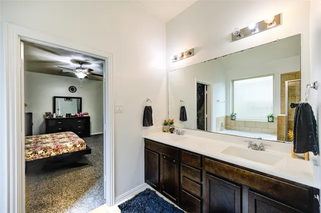 a en suite bathroom with a double vanity sink and a mirror