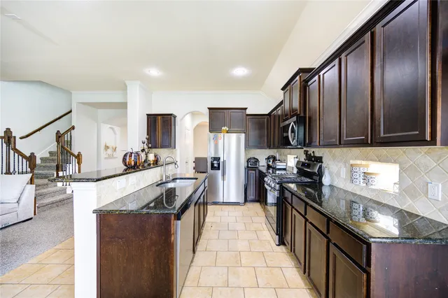 a kitchen with stainless steel appliances granite countertop a sink stove and refrigerator