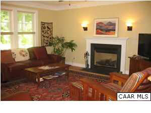 827 Village Road Charlottesville, VA 22903 - Photo 2 of 11 Family room has gas log fireplace, wall of windows and hardwood throughout first floor.