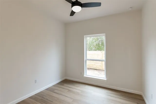 wooden floor in an empty room with a window