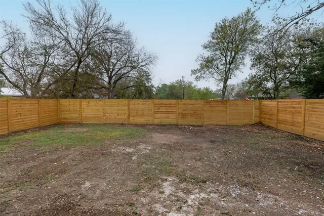 a view of a yard with wooden fence