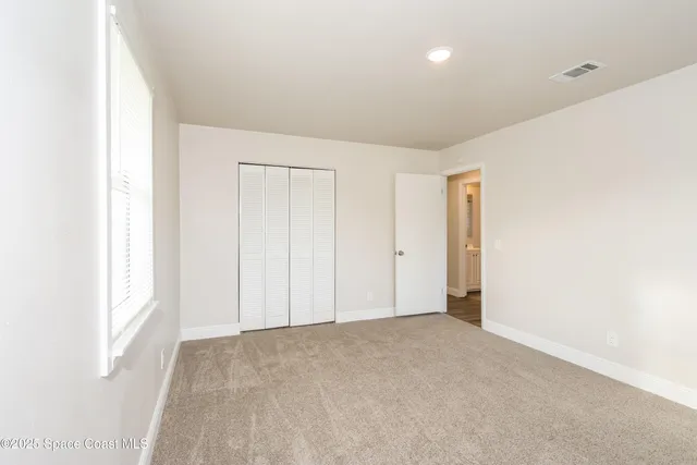 an empty room with windows and closet
