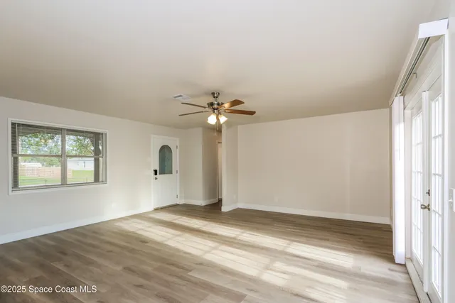 a view of a livingroom with a ceiling fan and window