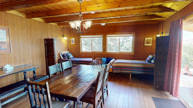 315 Abbey Road Moab, UT 84532 - Photo 16 of 46 Dining space featuring suspended lighting, wood-type flooring, a wood ceiling with exposed beams, and wooden walls