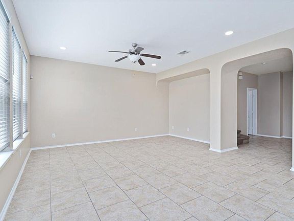 904 Lonesome Lilly Way Pflugerville, TX 78660 - Photo 9 of 34 Spacious living area featuring neutral-toned tile flooring, large windows with blinds, a ceiling fan, and recessed lighting