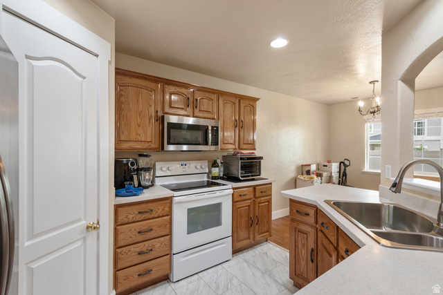802 Brookside Court Payson, UT 84651 - Photo 16 of 32 Kitchen with arched walkways, stainless steel appliances, wood finish cabinets, and light countertops