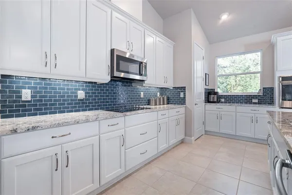 a kitchen with white cabinets and white appliances