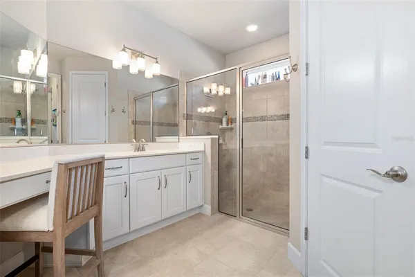 a bathroom with a double vanity sink mirror and shower